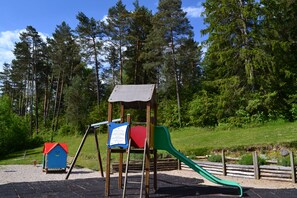 A playground with a swing set, slide, and small playhouse. - Vvf Villages Maisod (Maisod)