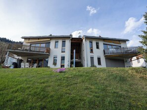 A two-story building with a balcony on the ground floor and a covered entrance. - Senda 517c, (Scuol) by Interhome (Scuol)