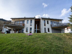 A two-story building with a balcony on the ground floor and a covered entrance. - Senda 517c, (Scuol) by Interhome (Scuol)