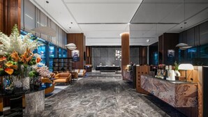 A modern lobby with a marble floor, seating area, reception desk, and decorative plants. - IntercityHotel Shanghai Hongqiao NECC (Shanghai)