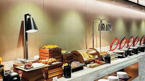 A buffet setup with various food items, plates, and a coffee machine. - IntercityHotel Shanghai Hongqiao NECC (Shanghai)