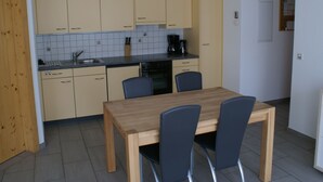 Une cuisine compacte comprenant une table et des chaises, une machine à café et un évier.