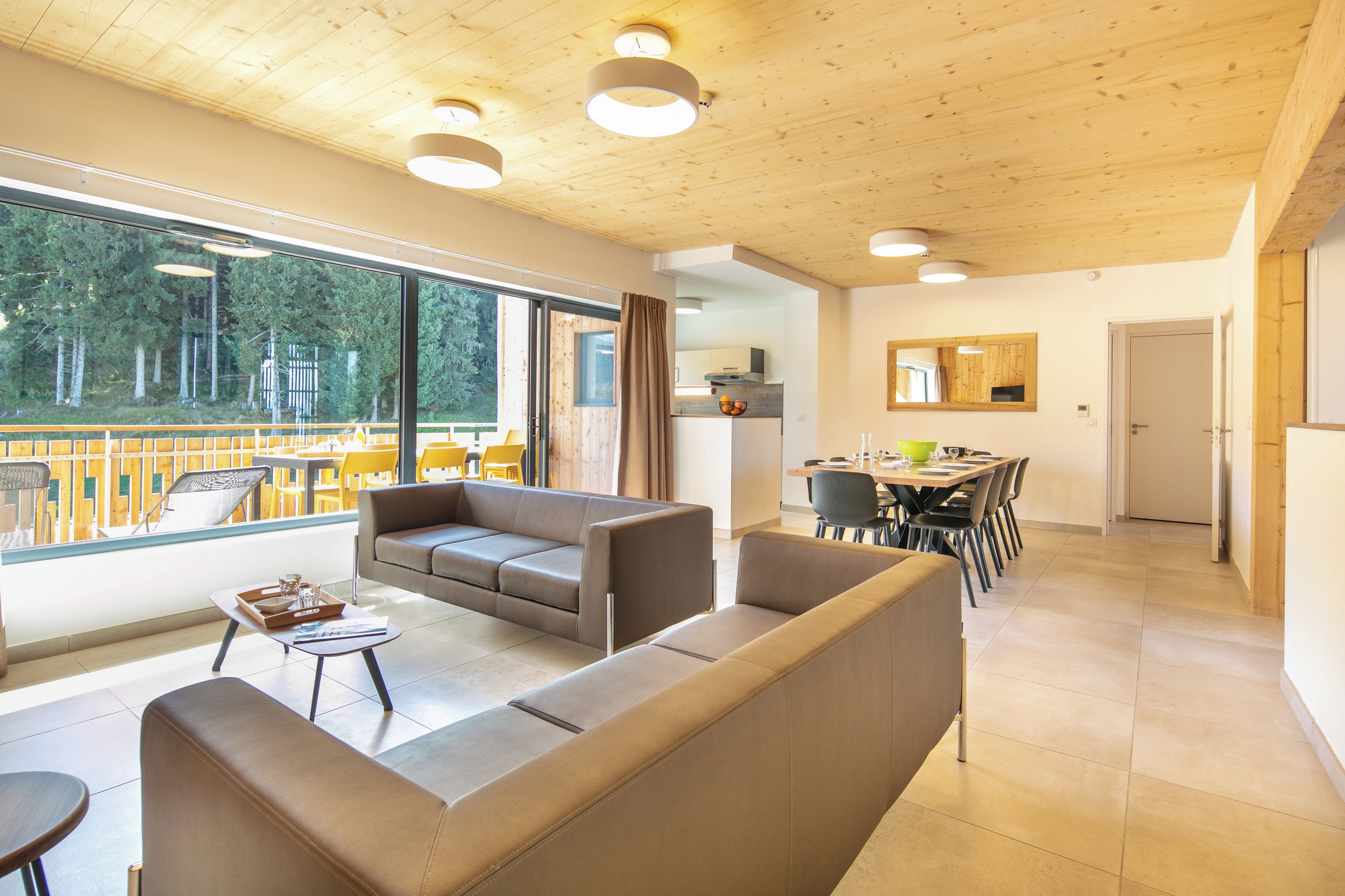 Una sala de estar moderna con un sofá, una mesa de centro y un comedor con sillas y una mesa.