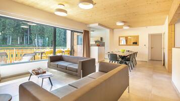 Una sala de estar moderna con un sofá, una mesa de centro y un comedor con sillas y una mesa.