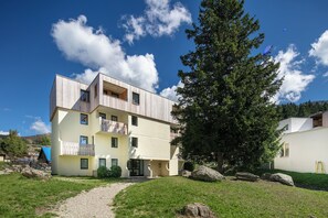 A multi-story building with a modern design, a visible balcony, and a gravel path leading to the entrance. - Vvf Villages Prapoutel (Les Adrets)