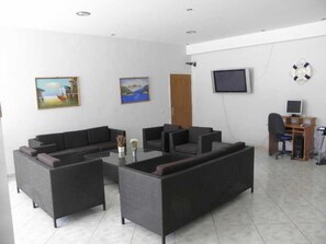 A modern living room with a sofa set, a TV, and a computer desk. - Vossos (Zakynthos)
