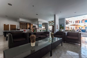 A modern lobby with a bar area, seating, and a view of the outside. - Vossos (Zakynthos)