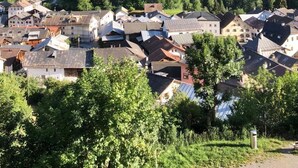 Une ville nichée dans une vallée, avec une église imposante et des montagnes en toile de fond.