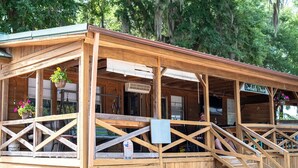 A wooden structure with a covered porch, a sign reading 'Dockside Diner,' and a staircase leading to an upper level. - 3-bedroom house in fabulous Summerton next to lake (Summerton)