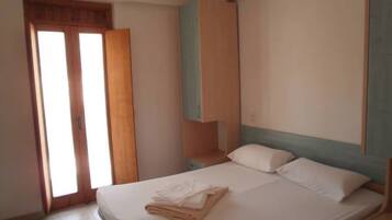 Una camera da letto con un letto, un comodino, un armadio e una porta.