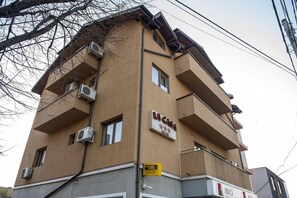 A multi-story building with balconies, air conditioning units, and a sign indicating 'La Casa.' - La Casa Nord Hotel (Bucharest)