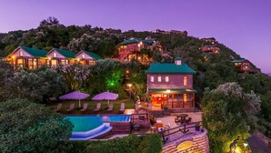 A hillside resort with multiple buildings, a swimming pool, and outdoor seating areas. - Under the Boardwalk Guest House (Wilderness)