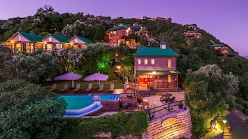Un resort en una ladera con varias construcciones, una piscina y zonas de estar al aire libre.