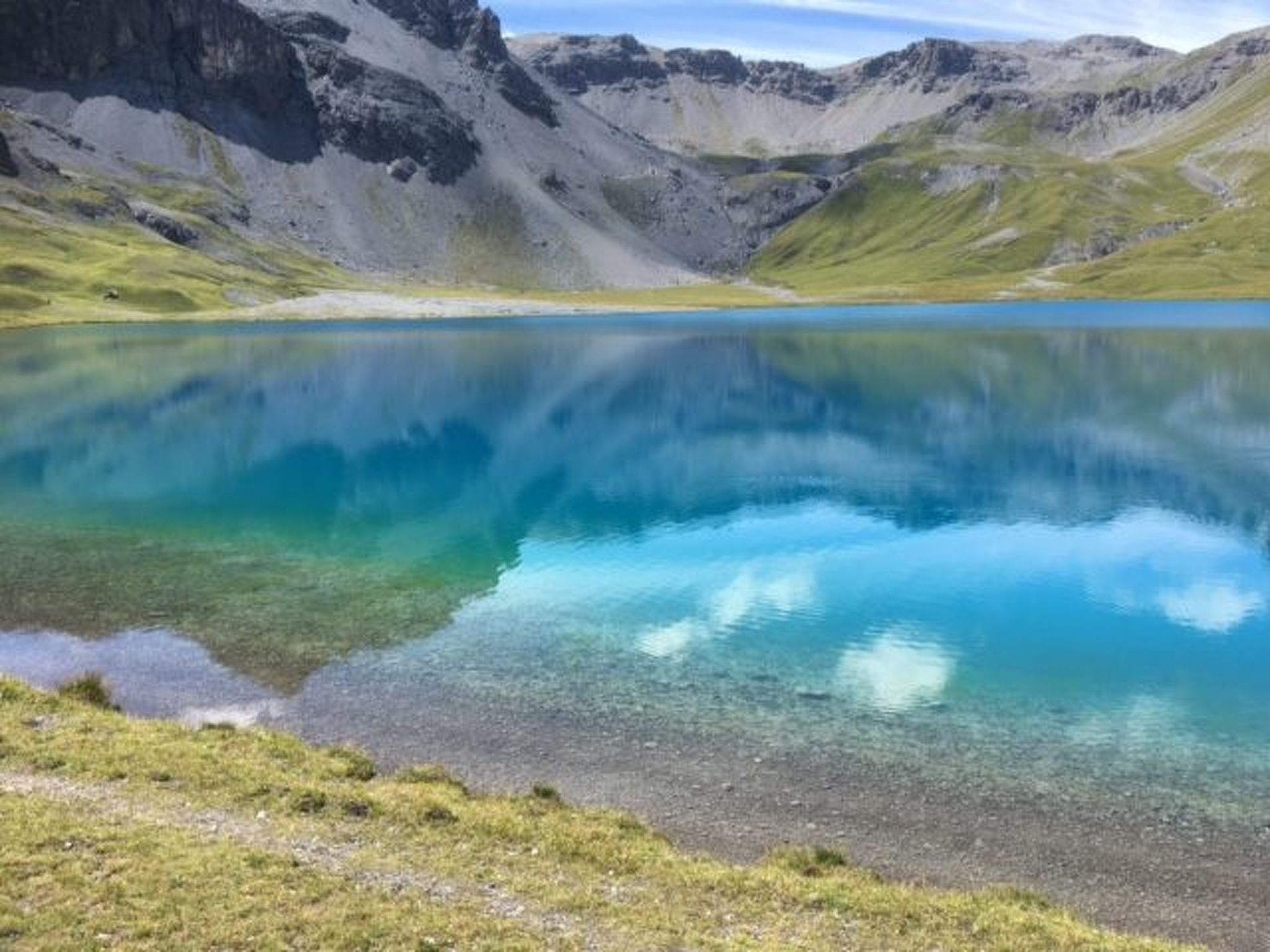 Un lac de montagne aux eaux limpides, entouré d’un paysage rocheux.