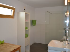 A bathroom with a shower, a sink, and a wooden table. - Chasa Sumovia, (Sta. Maria - Santa Maria Val Müstair) by Interhome (Sta. Maria GR)