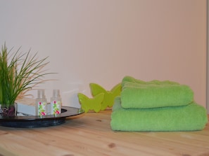 A bathroom with a wooden countertop, a green towel, and two bottles of lotion. - Chasa Sumovia, (Sta. Maria - Santa Maria Val Müstair) by Interhome (Sta. Maria GR)