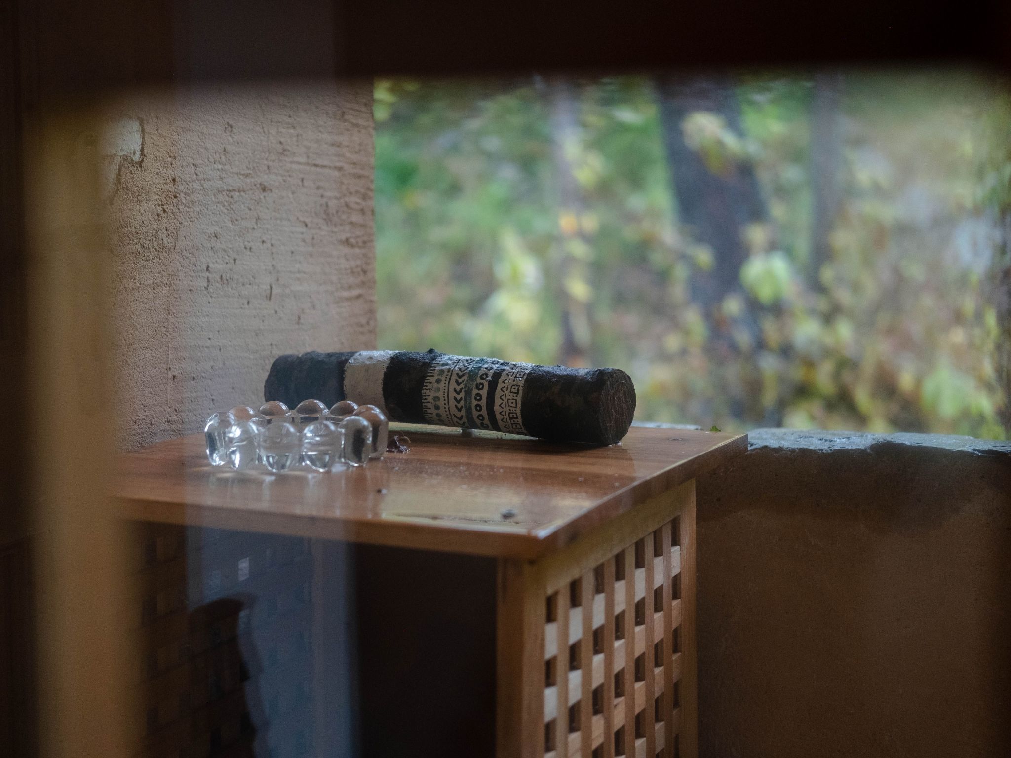 A wooden table with a rolled-up item and clear glasses.
