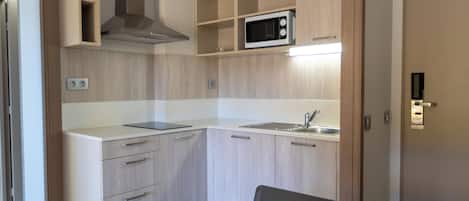 A modern kitchen with a microwave, sink, and cabinets.