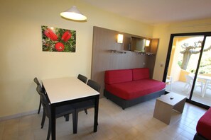 A room with a bed, a table, chairs, a TV, and a painting. - Paese Serenu (Porto-Vecchio)
