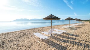 A beach with white lounge chairs and thatched umbrellas. - Paese Serenu (Porto-Vecchio)