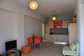 Un espace de vie moderne comprenant un coin repas, une cuisine et un coin salon.