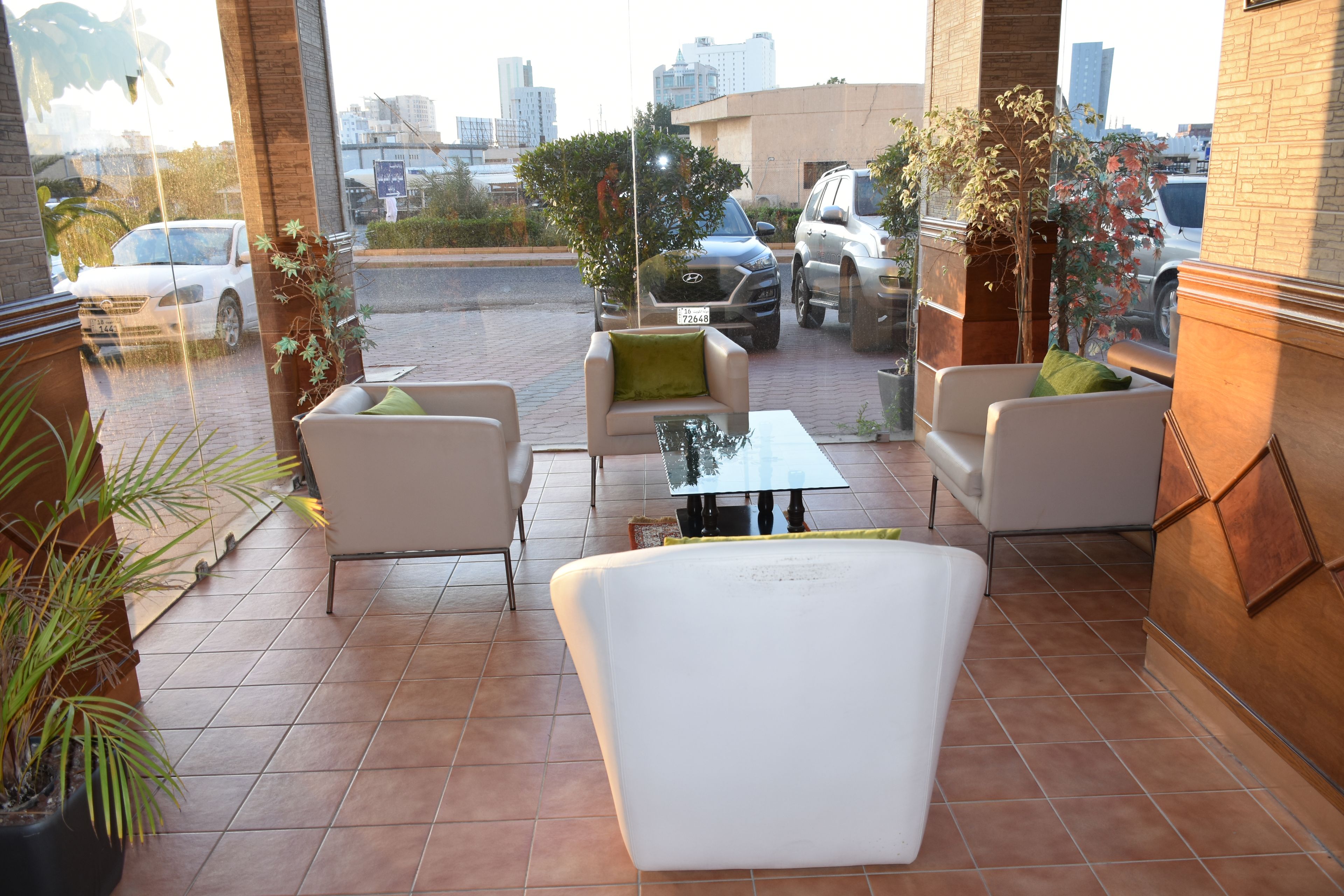 A terrace with outdoor seating, a view of the city, and a building with a brick facade.