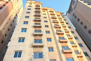 A high-rise building with multiple balconies, large windows, and a clear sky. - Arinza Tower Quality Suites (Salmiya)