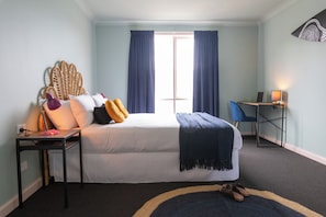 A bedroom with a bed, a desk with a computer, a chair, and a window with curtains. - Selina St Kilda Melbourne (Melbourne)
