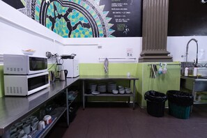 A kitchen with a microwave, coffee maker, and a chalkboard menu. - Selina St Kilda Melbourne (Melbourne)