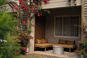 Una habitación con sofá, ventana y estructura de madera decorada con flores.