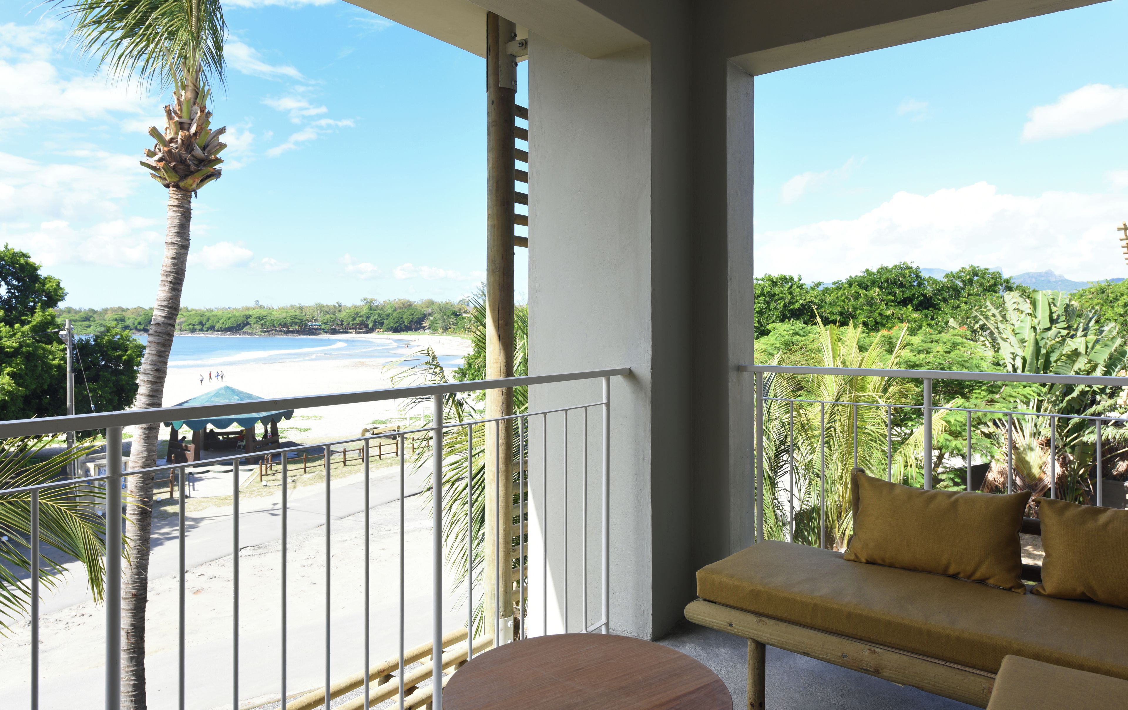 Un balcon avec vue sur une plage et des palmiers.
