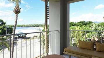 Un balcon avec vue sur une plage et des palmiers.