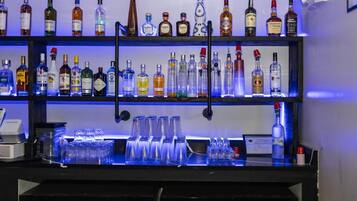 A bar area with multiple shelves of liquor bottles and glasses.