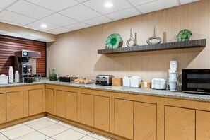 Cozinha moderna equipada com cafeteira, torradeira e televisão de tela plana.