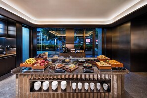 A buffet with various food items and plates arranged on a counter. - Crystal Hotel Lujiazui Financial Center (Shanghai)