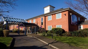 A hotel with a red brick facade, a covered entrance, and a sign for Premier Inn.