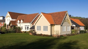 A row of houses with red-tiled roofs and a well-maintained lawn.