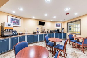 A hotel room with a kitchenette, a flat-screen TV, a large window, and a seating area with chairs and a table. - Knights Inn Searcy (Searcy)