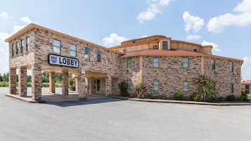A two-story building with a sign reading 'Lobby' at the entrance, featuring a brick facade and a red roof.