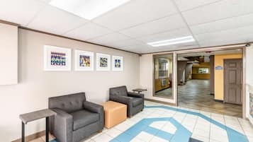 A waiting area with a sofa, chairs, a small table, and framed artwork on the wall.
