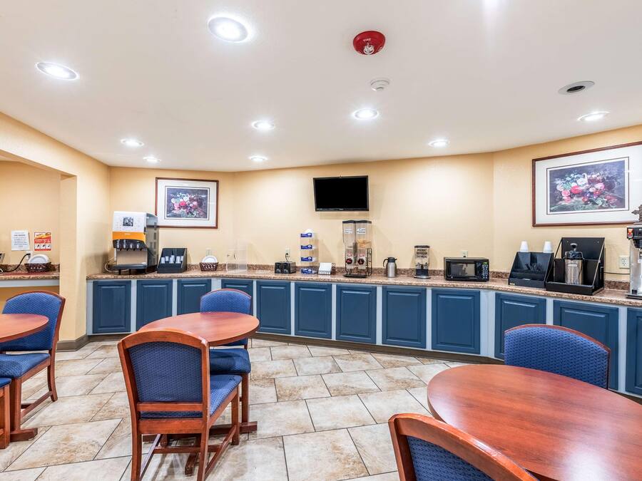 Eine Hotelküche mit blauen Schränken, einer Kaffeestation und einem Fernseher an der Wand.