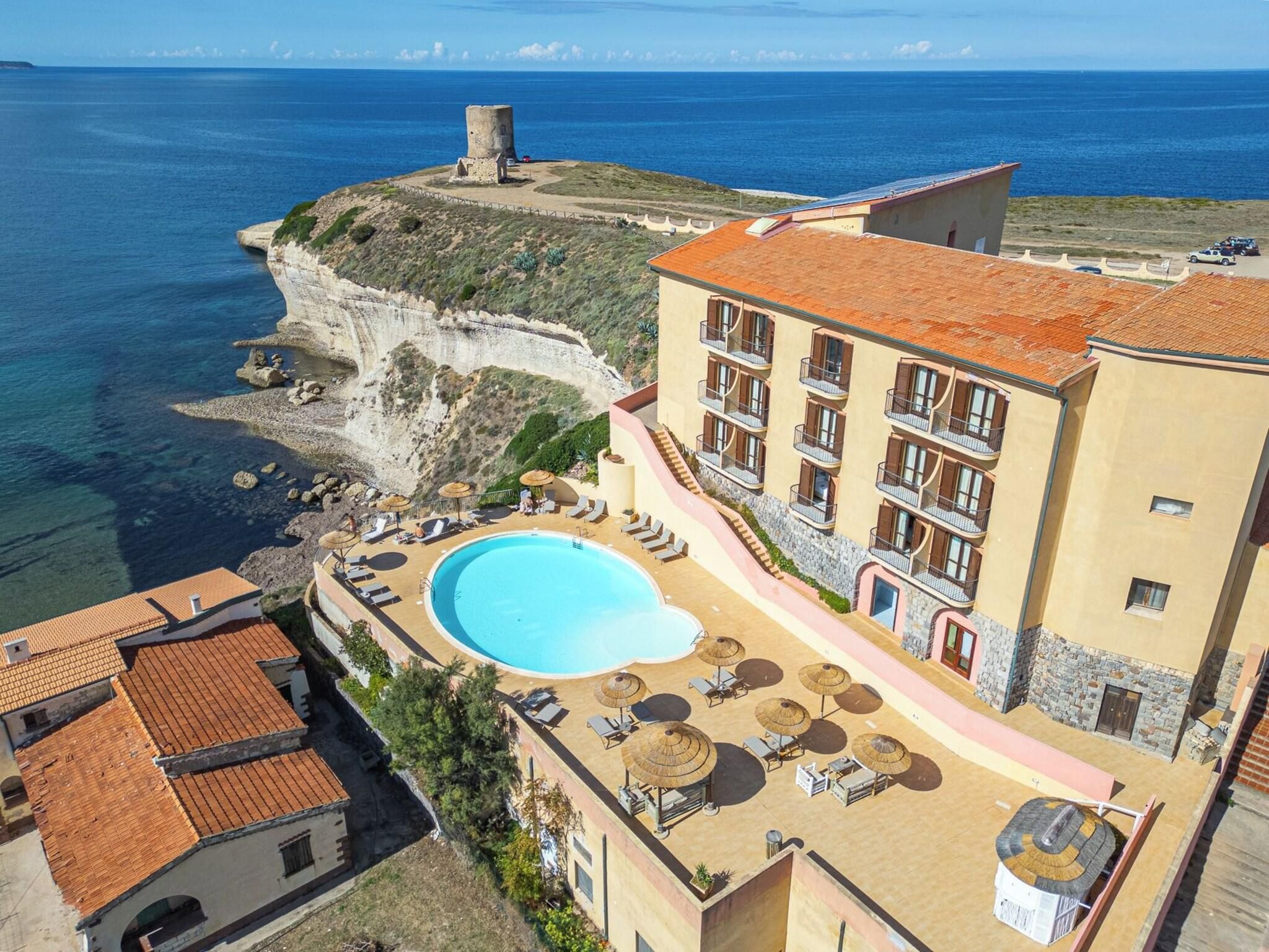 Ein Hotel mit Pool, Felsblick und einem Turm.