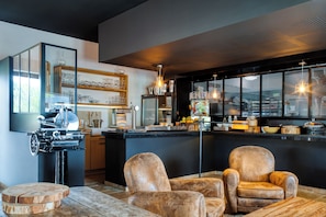 Una cocina moderna con barra, muebles de madera e iluminación colgante.