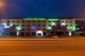 Un hôtel avec une enseigne indiquant « Oak Plaza Hotel » et « East Airport », ce qui permet de situer son emplacement.