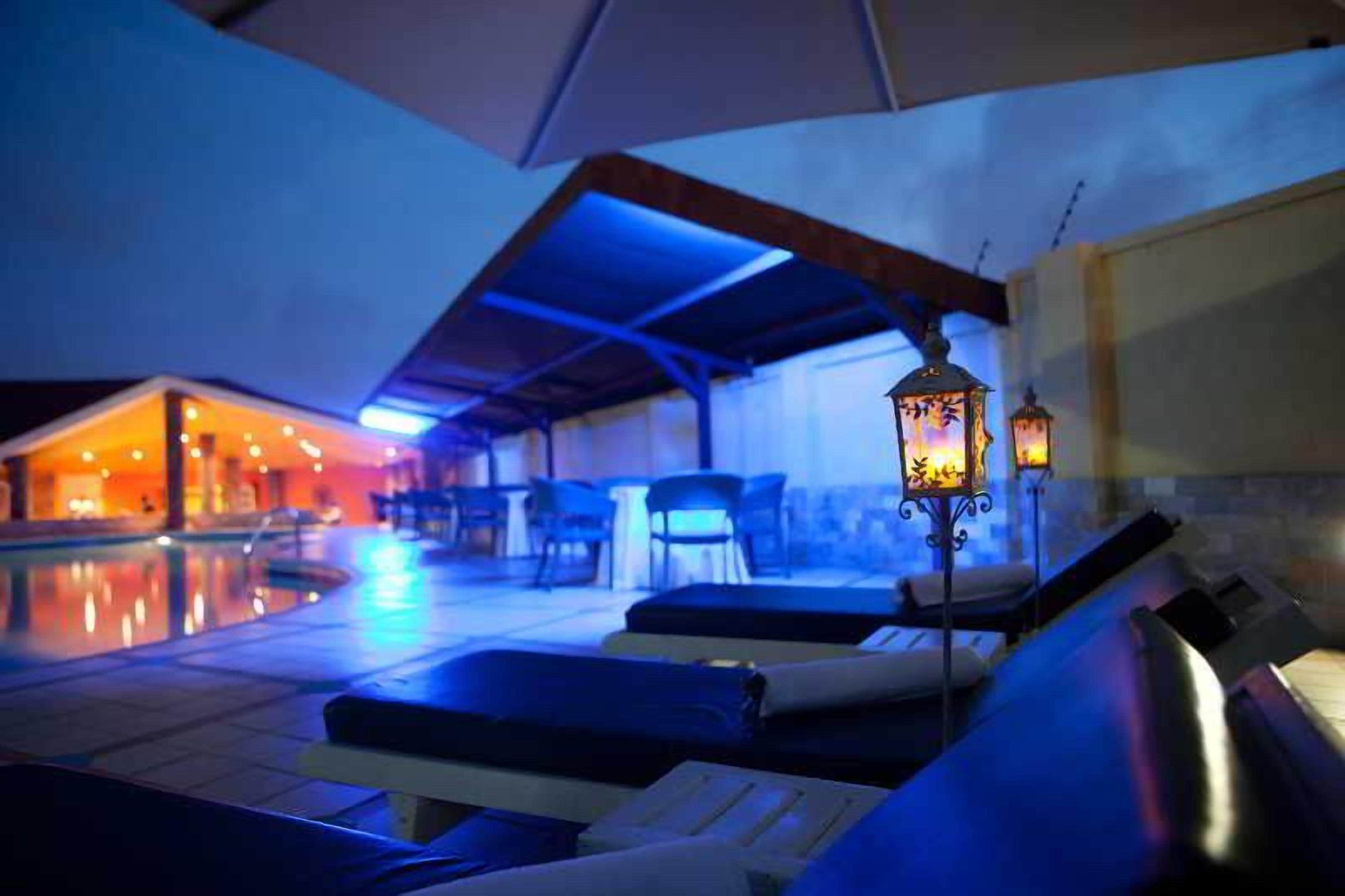 A poolside area with lounge chairs and a covered seating area.