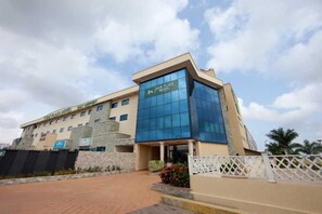 A hotel with a modern facade, a prominent entrance, and a landscaped area in front. - Oak Plaza Hotel East Airport (Accra)