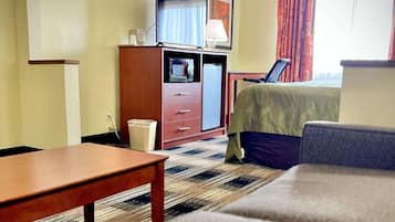 Une chambre d’hôtel équipée d’un lit, d’un bureau, d’une télévision, d’une lampe et d’une poubelle.