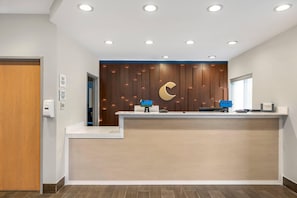 A reception desk with a wooden panel wall, a crescent moon design, and a 'WELCOME' sign. - Quality Inn & SUI Wisconsin Dells Dwntn-waterparks (Wisconsin Dells)