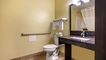 A bathroom with a toilet, a sink, a mirror, and a towel rack.