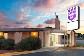 Ett Knights Inn-hotell med en skylt, en överbyggd entré och en parkeringsplats.